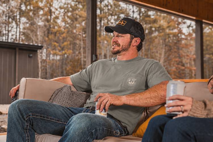 Man in a graphic pocket tee relaxing on a porch in autumn